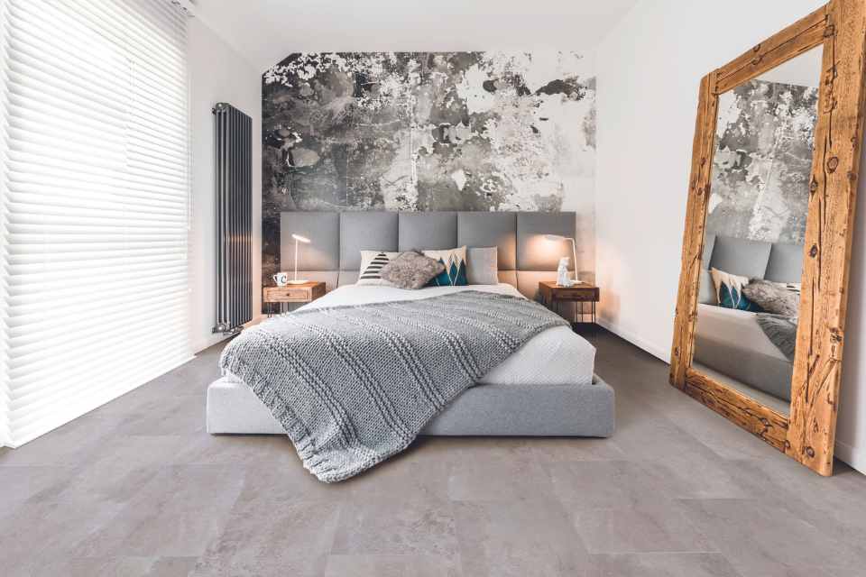 limewash bedroom with grey concrete-look vinyl floor and raw wood mirror